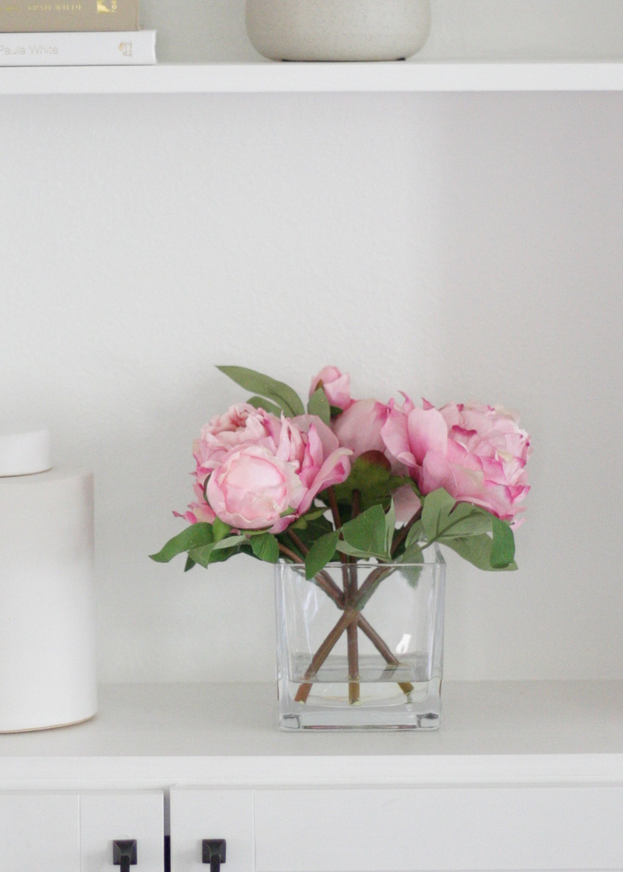 pink peony arrangement on bookcase